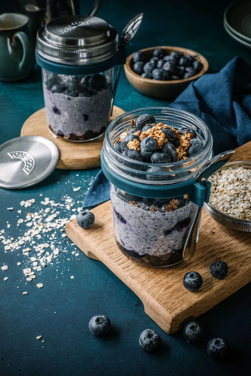 Close view of the smooth berry oat batter in the glass jar with its teal silicone collar