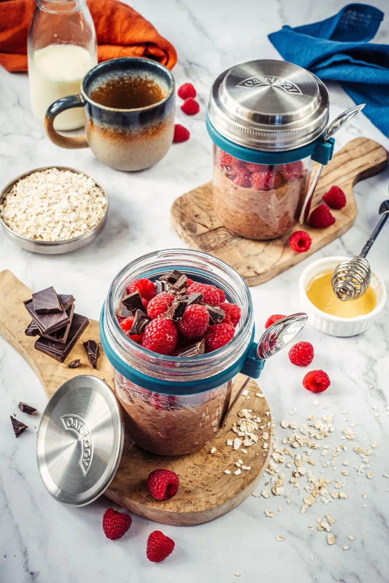 Side view of the chocolate oats showing the raspberry ripple running through the chia layer in the glass jar with its teal silicone collar