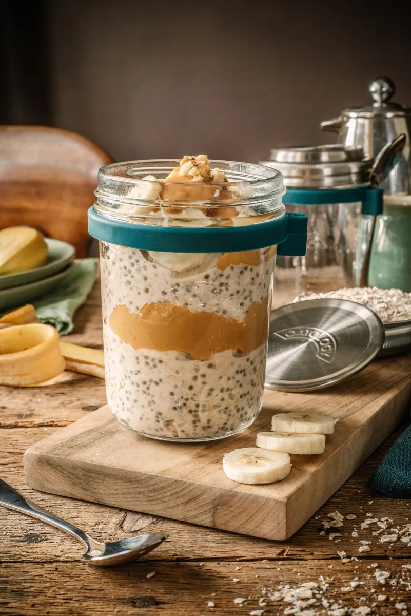 Side view showing the chia and peanut butter layers in the glass jar with its teal silicone collar